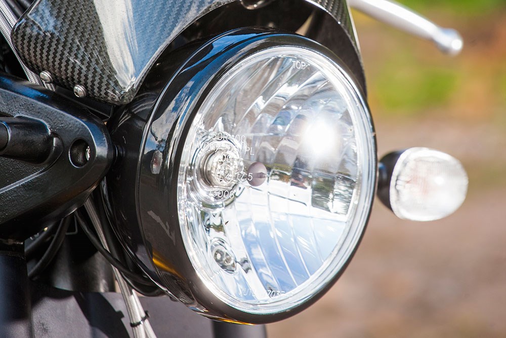 Cụm đèn pha tròn cổ điển được sơn đen, và fairing nhỏ với chất liệu carbon có sự pha trộn rất hài hòa giữa cổ điển và hiện đại Cụm đèn pha tròn cổ điển được sơn đen, và fairing nhỏ với chất liệu carbon có sự pha trộn rất hài hòa giữa cổ điển và hiện đại