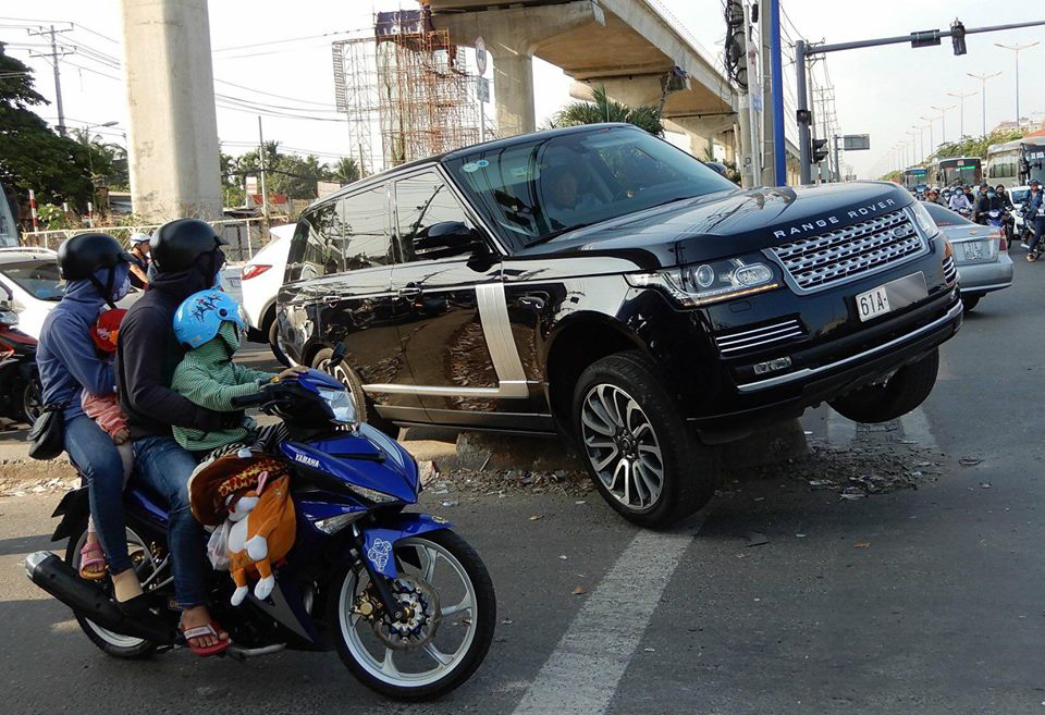 Nhiều người đi đường bất ngờ khi chiếc SUV hạng sang bị mắc kẹt tại dải phân cách