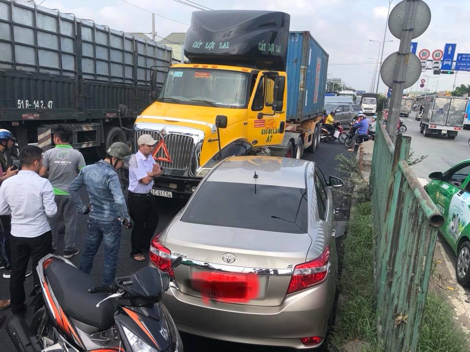 Chiếc Toyota Vios vướng vào sườn xe container và xoay ngược 180 độ