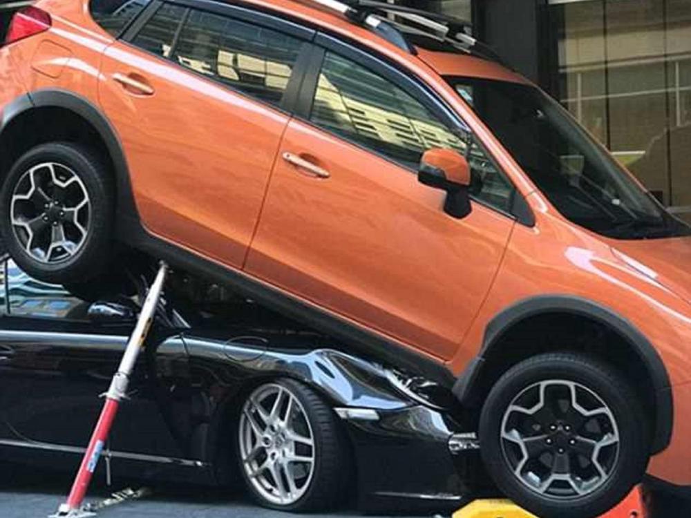 Subaru XV màu cam tươi đè đầu cưỡi cổ chiếc xe thể thao mui trần màu đen