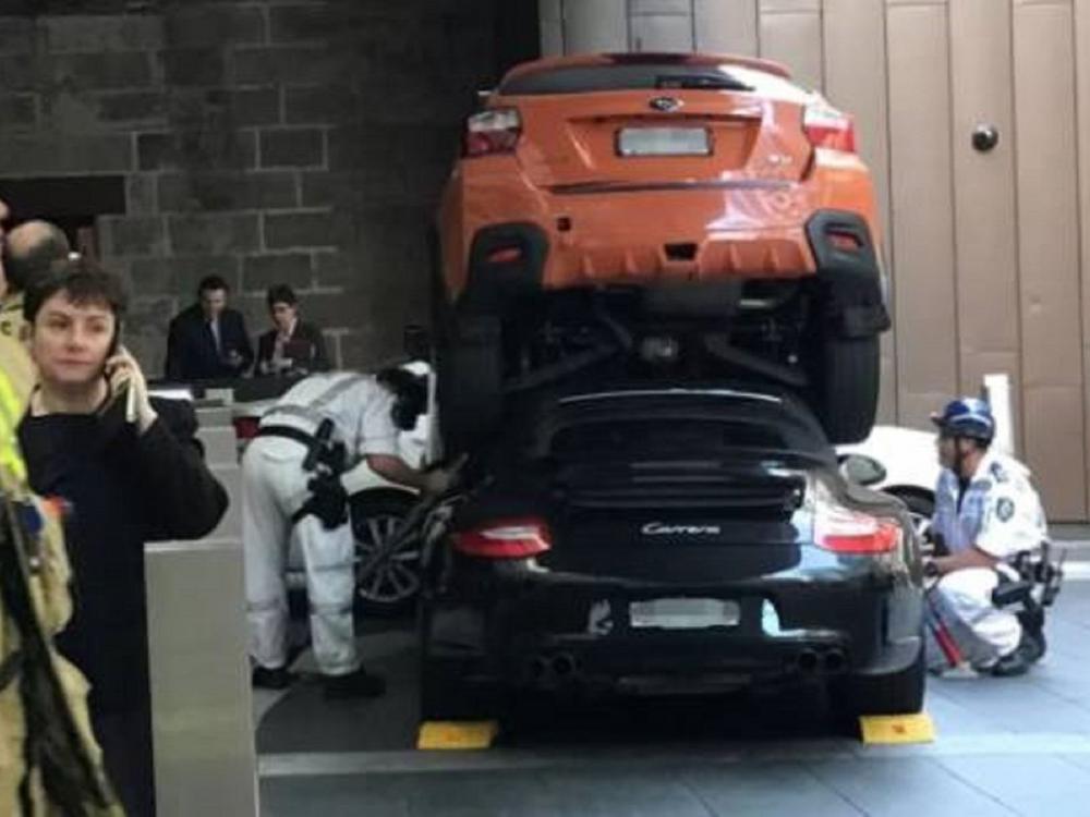 Lực lượng chức năng đang cắt phần mui mềm của Porsche 911 Carrera S màu đen để lôi người cầm lái ra bên ngoài