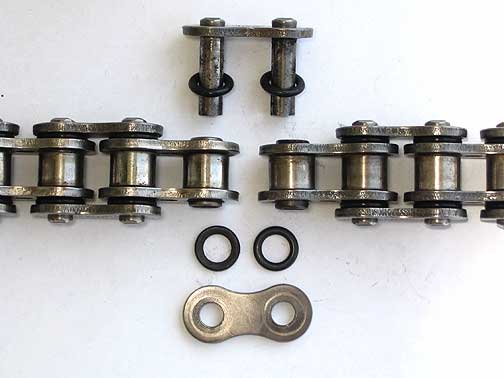 Vòng đẹm cao su được đặt giữa tấm che và mắt xích Vòng đẹm cao su được đặt giữa tấm che và mắt xích