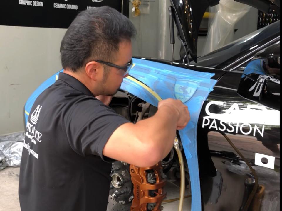 Một người thợ của Liberty Walk đang cắt vòm bánh xe của Ferrari 488 GTB để chuẩn bị độ body kit thân rộng