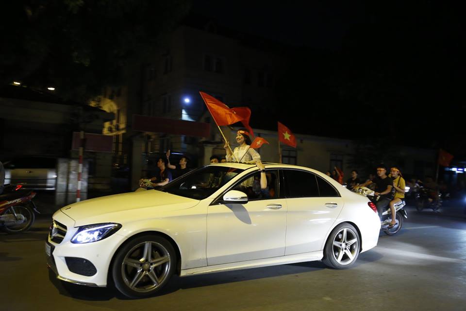 Đứng trong ô tô và thò người ra ngoài qua cửa sổ trời như thế này là hình ảnh rất dễ bắt gặp trên đường phố thủ đô trong đêm ăn mừng chiến thắng