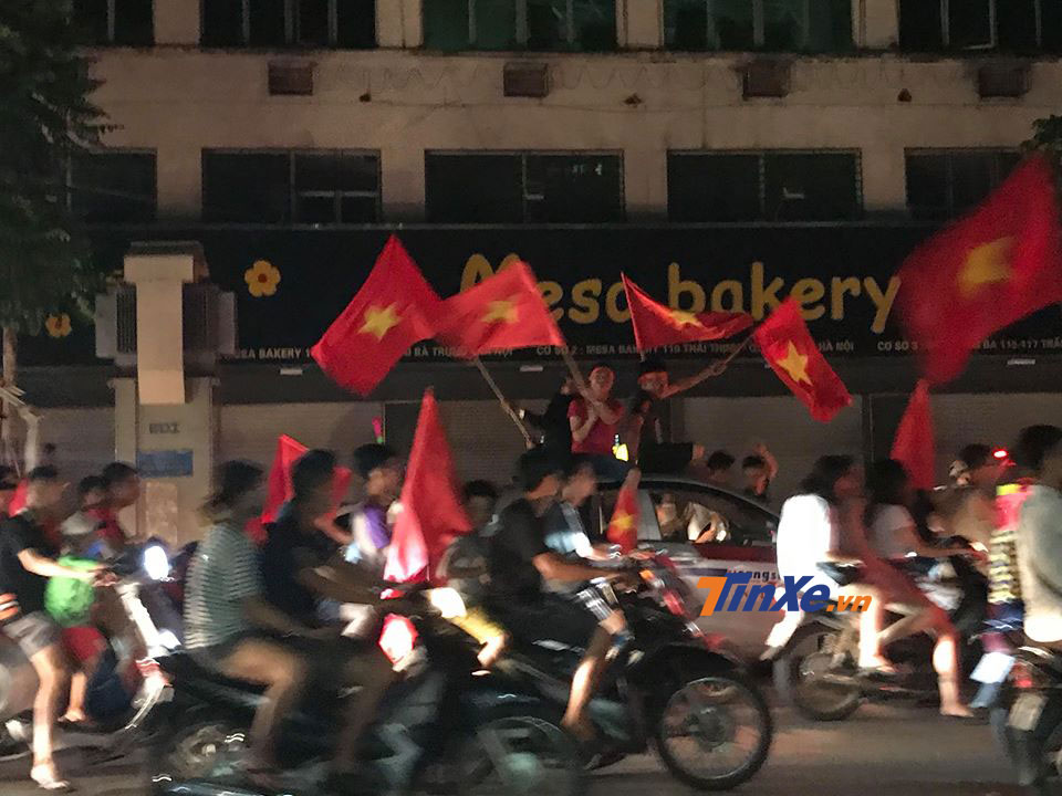 Một nhóm thanh niên còn liều mình ngồi trên nóc xe taxi để vẫy cờ