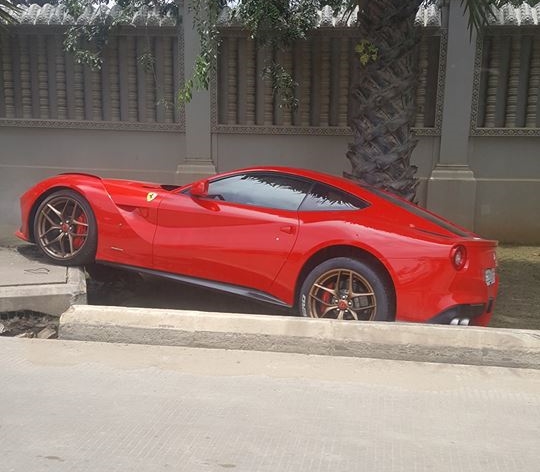 Phần đầu siêu xe Ferrari F12 Berlinetta gác hẳn lên nắp cống bên đường