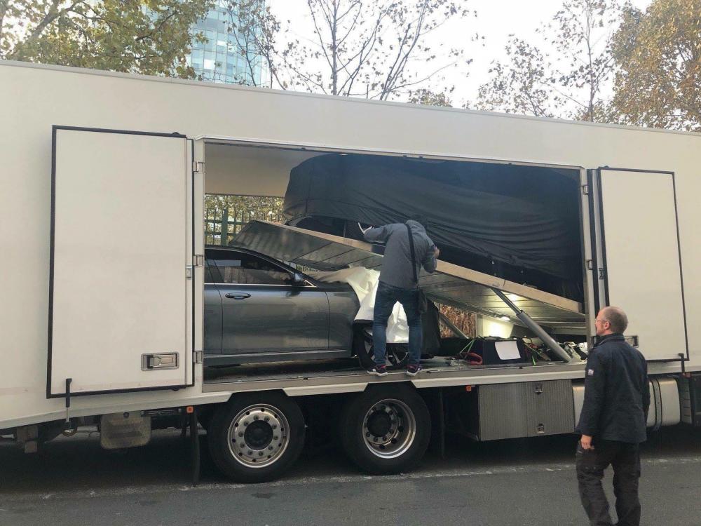 Các nhân viên đang thực hiện việc chuyển xe xuống khỏi xe chuyên dụng Các nhân viên đang thực hiện việc chuyển xe xuống khỏi xe chuyên dụng