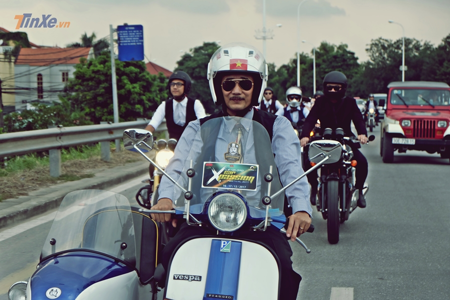 Quý ông đứng tuổi bên cạnh chiếc Vespa cổ được độ 3 bánh kèm thuyền