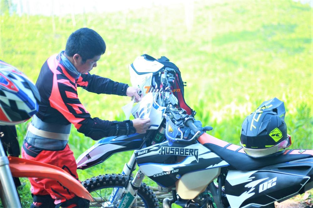 Một vận động viên đang dán số báo danh cho đồng đội của mình. Một vận động viên đang dán số báo danh cho đồng đội của mình.