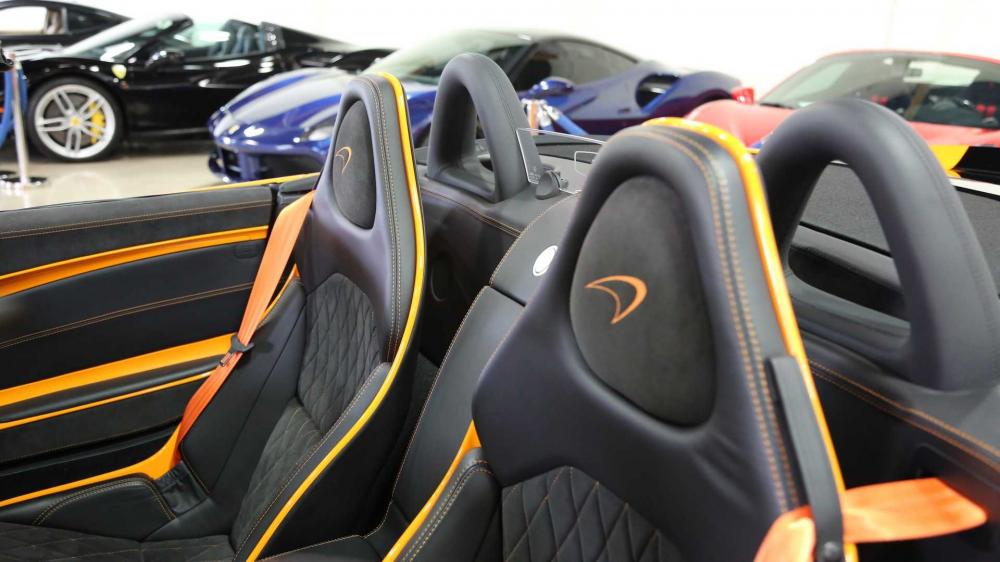 Thành cửa bọc da Alcantara màu đen thêu hình kim cương và logo McLaren trên tựa đầu ghế ngồi màu cam Thành cửa bọc da Alcantara màu đen thêu hình kim cương và logo McLaren trên tựa đầu ghế ngồi màu cam