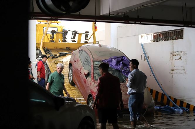 Lần lượt các ô tô được xe cứu hộ chuyên dụng kéo ra khỏi tầng hầm để đưa đi sữa chữa