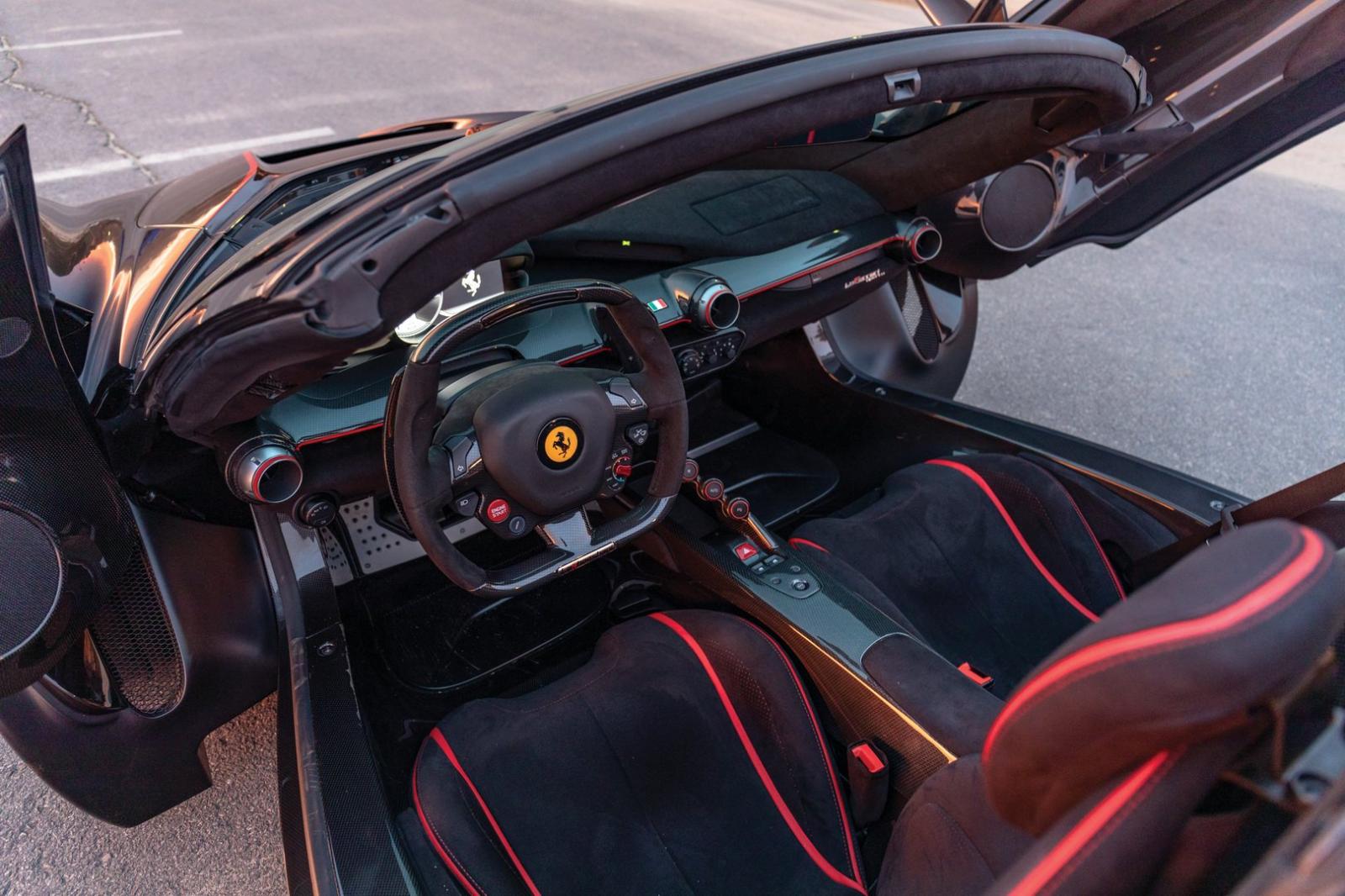 Khoang lái xe bọc da màu đen với các đường sọc đỏ làm điểm nhấn