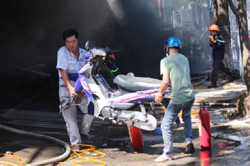 Một số người dân vận chuyển xe trong cửa hàng ra khỏi nơi cháy 