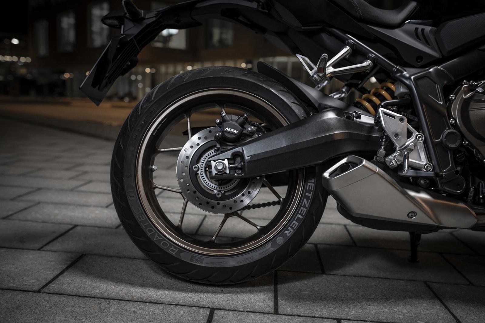 Dàn chân sau gồm giảm xóc lò xo trụ đơn, càng thép và bộ vành nhôm Dàn chân sau gồm giảm xóc lò xo trụ đơn, càng thép và bộ vành nhôm