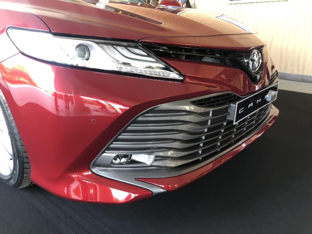 Thiết kế ngoại thất không có gì khác so với 2 mẫu Camry 2019 mới được đưa về kho. Phần đầu xe là lưới tản nhiệt cỡ lớn vuốt xuống cản trước sắc lẹm. Phía bên trên là đèn pha Hi-LED cùng các cảm biến va chạm đầy đủ cả trước lẫn sau