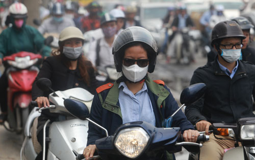 Người đi xe máy đeo khẩu trang tránh bụi trên đường Minh Khai Người đi xe máy đeo khẩu trang tránh bụi trên đường Minh Khai