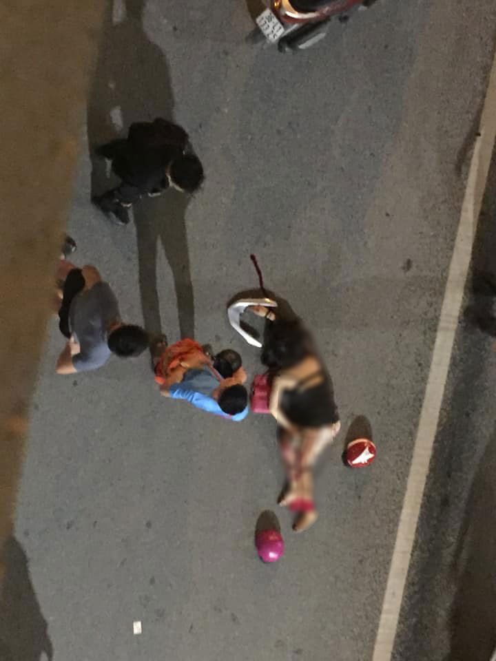 Một người phụ nữ nằm cạnh tay dắt phía sau bị rơi ra từ chiếc xe máy Một người phụ nữ nằm cạnh tay dắt phía sau bị rơi ra từ chiếc xe máy