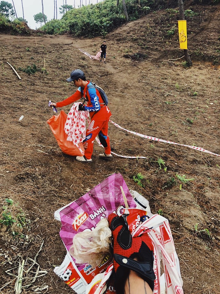Mặc nguyên bộ đồng phục thi đấu và dọn rác quanh khu vực trường đua