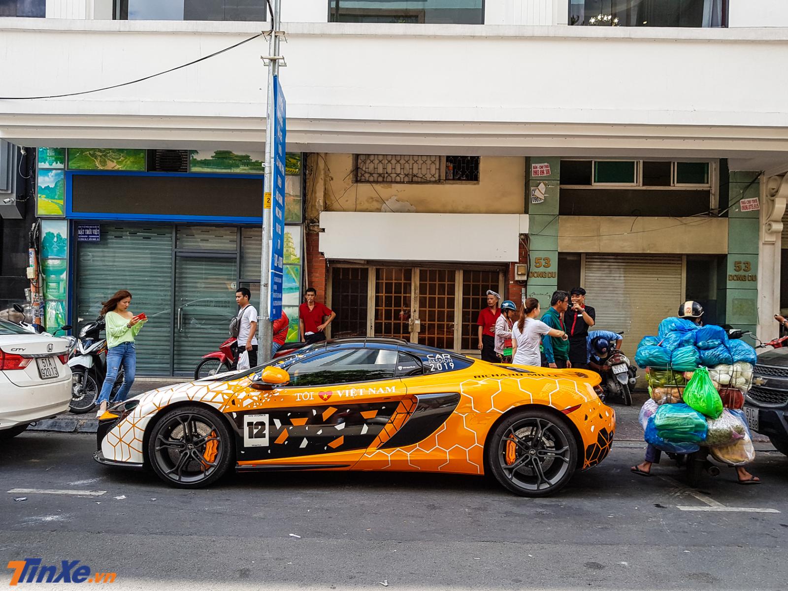 Nhiều người nói đùa với nam thanh niên chạy xe máy đang vận chuyển rau củ hãy cẩn thận kẻo làm xước sơn chiếc siêu xe McLaren 650S Spider