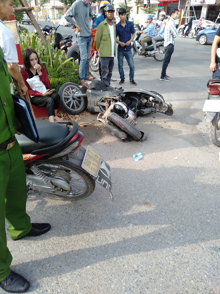 Cô gái bị thương ngồi thẫn thờ bên chiếc xe tay ga gãy làm đôi
