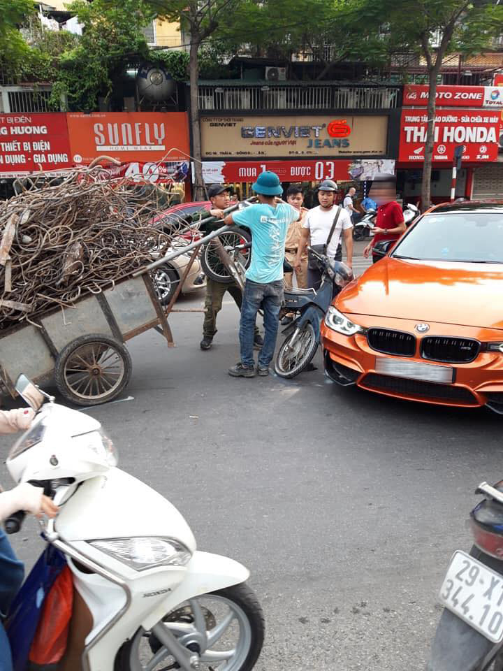 Hiện trường vụ tai nạn của chiếc BMW M3 màu cam và xe máy kéo rơ-moóc chở sắt tại Thái Hà, Hà Nội