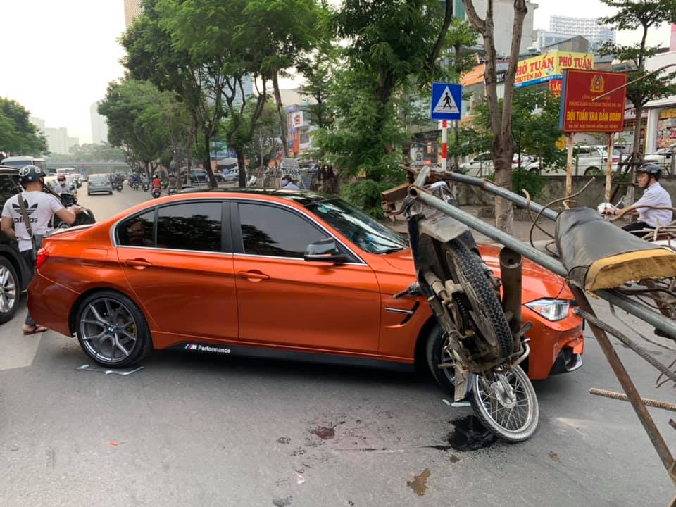 Chiếc xe máy kéo theo rơ-moóc chở sắt tông hông xe BMW M3 màu cam