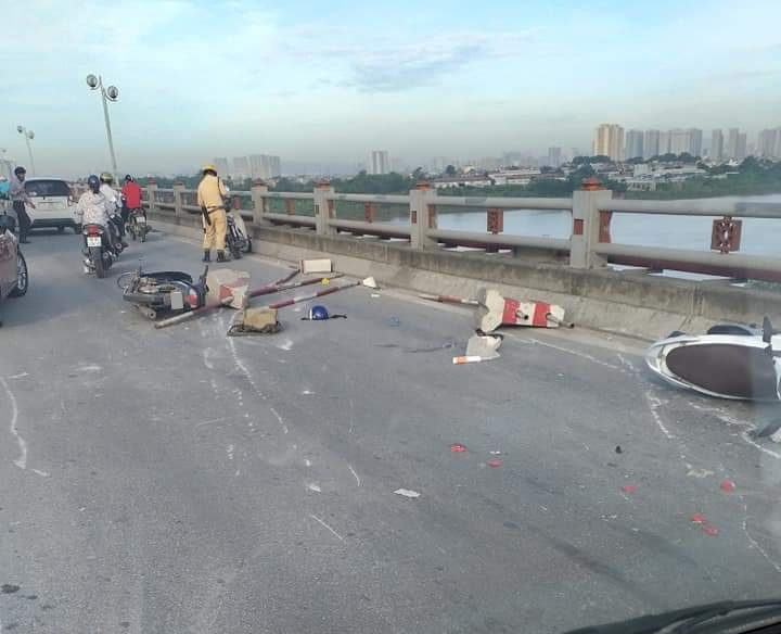 Hai chiếc xe máy bị hư hỏng cùng dải phân cách bị xe container tông vào