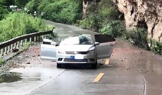 Chạy trên đường núi, chiếc Volkswagen bị đá lở rơi trúng nóc, bẹp dúm