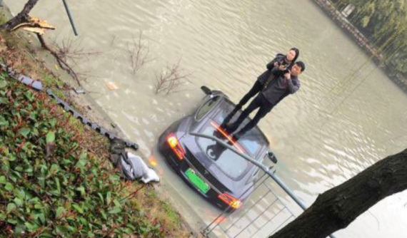 Tesla Model S lao xuống sông, cặp đôi leo ra ngoài và đứng trên nóc xe để chụp ảnh
