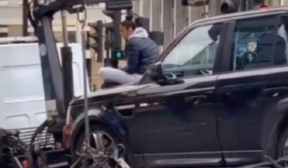 Cô gái "cố thủ" trên nắp ca-pô của chiếc SUV hạng sang Range Rover để ngăn cảnh sát cẩu xe đi