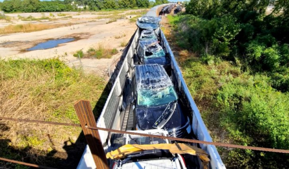 Chạm vào gầm cầu, nóc toa tàu bị dồn về phía sau, làm hỏng lô xe Ford Explorer mới