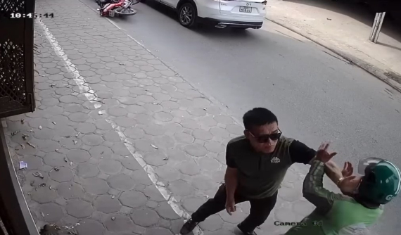 Video: Thiếu quan sát khi đi từ vỉa hè xuống đường, tài xế GrabBike bị người lái ô tô Mazda đấm túi bụi