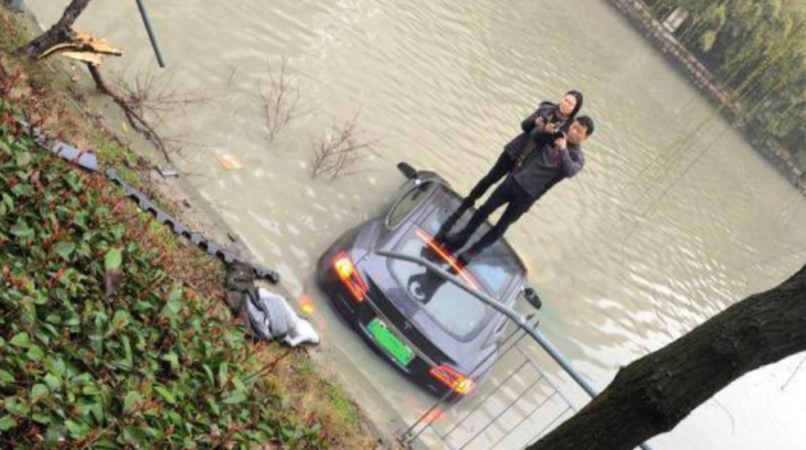 Tesla Model S lao xuống sông, cặp đôi leo ra ngoài và đứng trên nóc xe để chụp ảnh