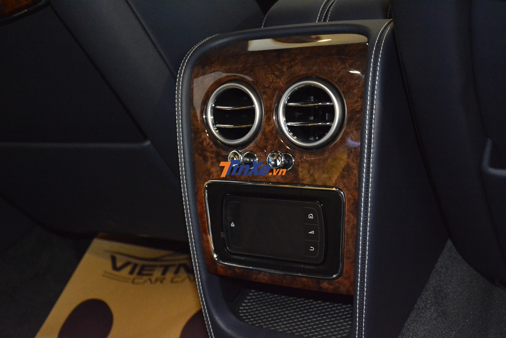 Màn hình cảm ứng ở ngay phía sau của hàng ghế phía trước cũng được óp gỗ óc chó xung quanh