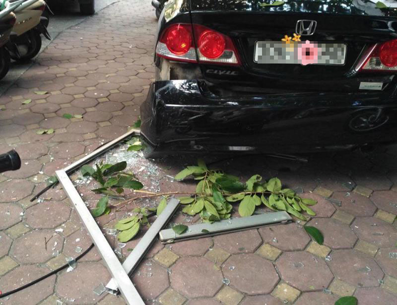 Cửa nhôm kính rơi xuống đất làm bung cản sau của chiếc Honda Civic đang đỗ Cửa nhôm kính rơi xuống đất làm bung cản sau của chiếc Honda Civic đang đỗ