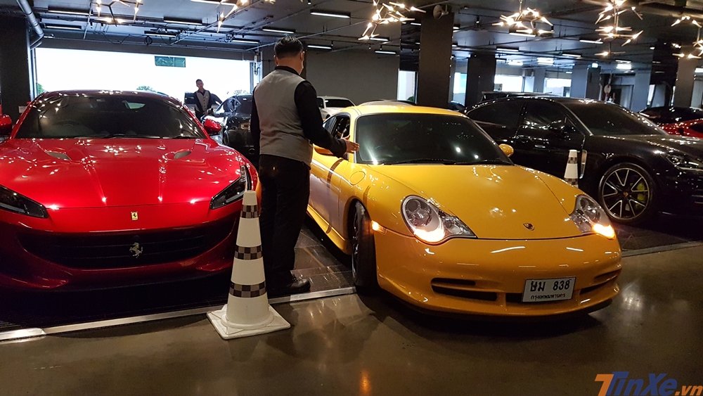 Một chiếc Porsche 911 GT3 đời 2000 đang được lơ xe cho vào vị trí đỗ cạnh siêu xe mui trần Ferrari Portofino và Porsche Panamera.