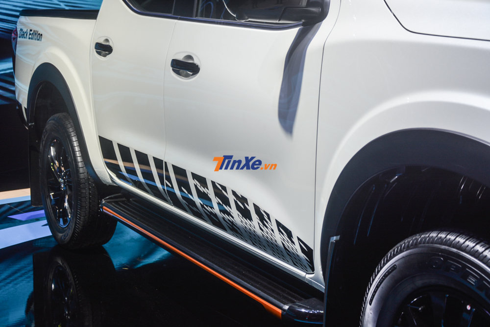 Bên hông xe Nissan Navara bản giới hạn còn có thêm bộ tem sọc màu đen, bệ bước chân hoàn thành màu đen cùng viền cam rất nổi bật