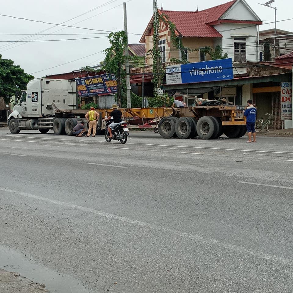 Cửa bên ghế lái của chiếc xe ben nằm trên rơ-moóc của xe container Cửa bên ghế lái của chiếc xe ben nằm trên rơ-moóc của xe container