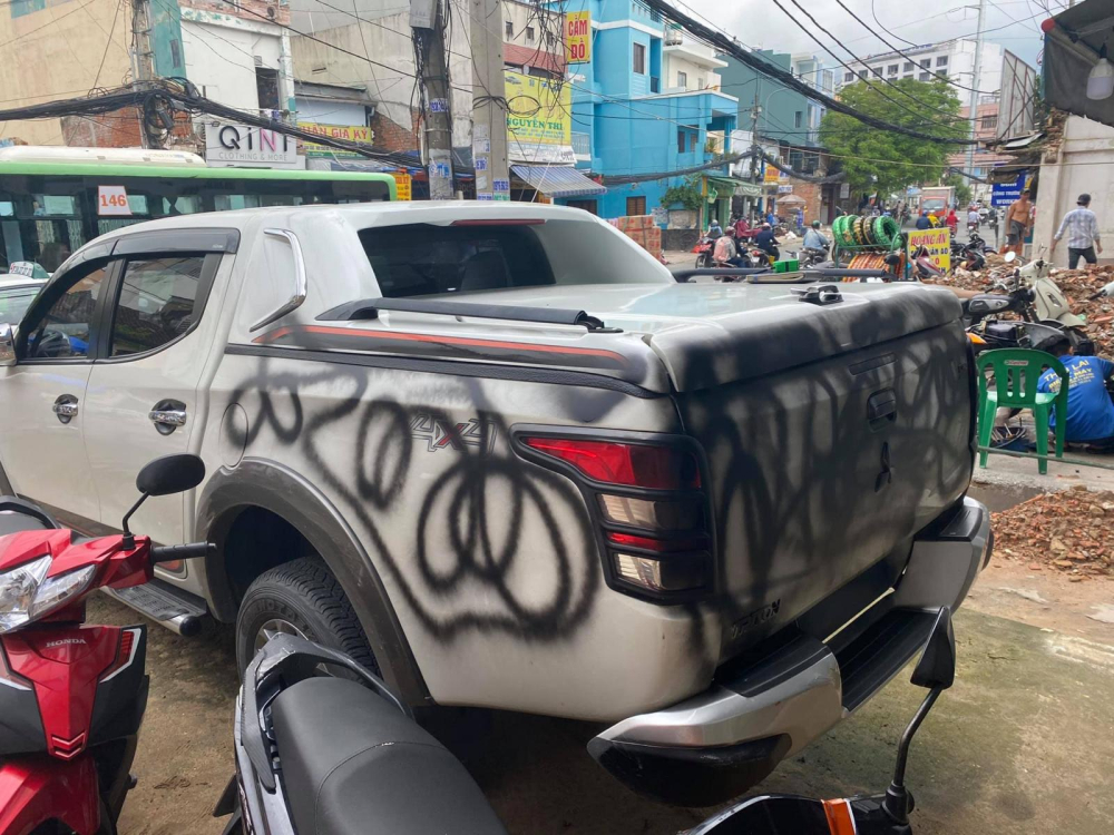 Chiếc ô tô bị xịt sơn lên nửa thân xe phía sau Chiếc ô tô bị xịt sơn lên nửa thân xe phía sau