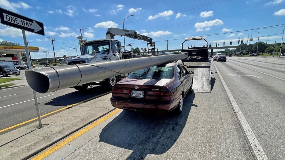 Cột điện được buộc trên nóc của chiếc Toyota Camry đời cũ Cột điện được buộc trên nóc của chiếc Toyota Camry đời cũ