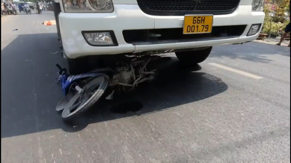 Chiếc xe máy nằm dưới gầm xe ben Chiếc xe máy nằm dưới gầm xe ben