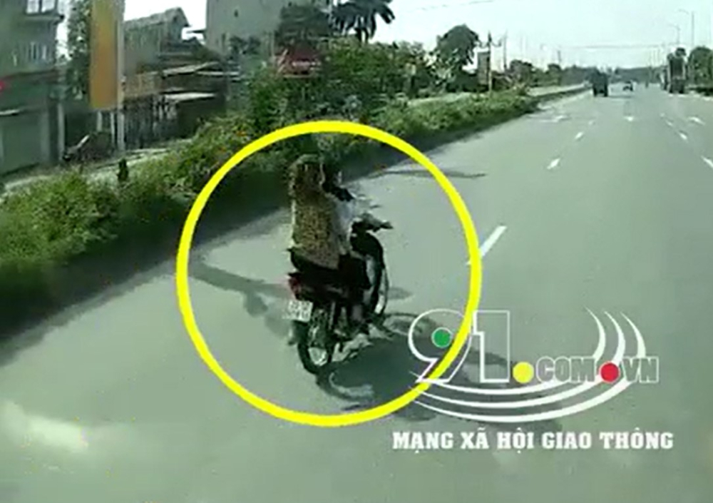 Hai cô gái không đội mũ bảo hiểm, đi xe máy trên đường trục chính của Khu công nghiệp Bắc Thăng Long Hai cô gái không đội mũ bảo hiểm, đi xe máy trên đường trục chính của Khu công nghiệp Bắc Thăng Long