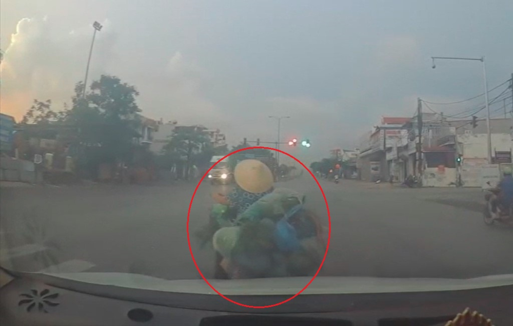 Người phụ nữ đi xe đạp điện chở rau sang đường bất cẩn Người phụ nữ đi xe đạp điện chở rau sang đường bất cẩn