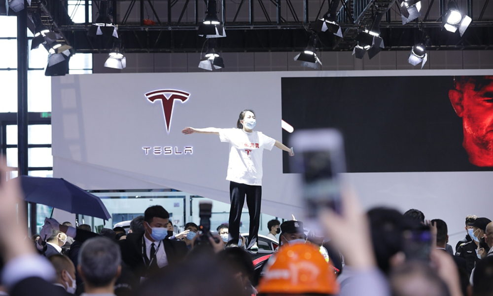 Người phụ nữ leo lên nóc chiếc ô tô Tesla trong triển lãm Ô tô Thượng Hải 2021