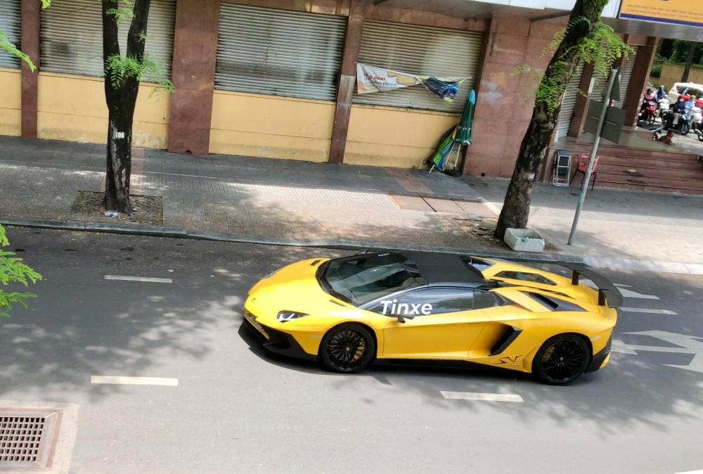 Nhưng Audi R8 không phải là tâm điểm chính, thay vào đó là chiếc siêu xe giới hạn Lamborghini Aventador SV Roadster lướt qua con đường Nguyễn Du để lại những âm thanh Nhưng Audi R8 không phải là tâm điểm chính, thay vào đó là chiếc siêu xe giới hạn Lamborghini Aventador SV Roadster lướt qua con đường Nguyễn Du để lại những âm thanh bụp bụp bụp phát ra từ ống xả độ của xe khiến không ít người thích thú. Số lượng siêu xe mui trần Lamborghini Aventador SV Roadster được sản xuất trên toàn thế giới là 500 chiếc và hiện tại chỉ có đúng 2 xe được mang về dải đất hình chữ S và đều định cư ở Sài thành. Chiếc xe Lamborghini Aventador SV Roadster trong bài viết là xe đầu tiên vè nước và sở hữu màu sơn vàng nhám.