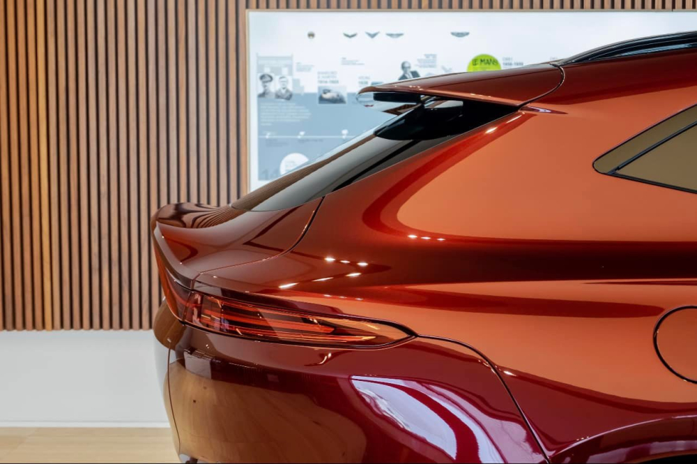 Ngoài màu sơn đỏ Liquid Crimson thời trang, ngoại thất của chiếc SUV hạng sang Aston Martin DBX này còn có nhiều chi tiết bằng sợi carbon bóng như thanh nẹp bên sườn, tay nắm cửa và vỏ gương.