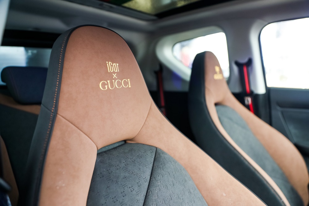 Ghế được bọc da và da lộn với logo Gucci thêu trên tựa đầu ghế