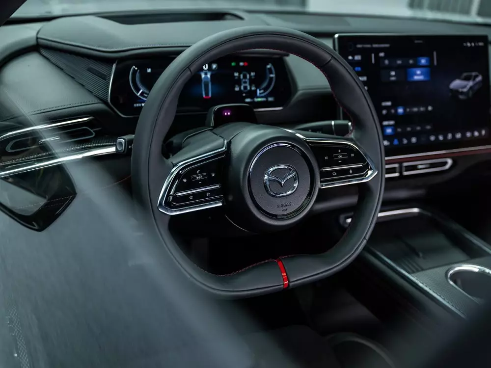 Vô lăng của Mazda EZ-6 Sports Edition có thiết kế vát đáy và đi kèm vạch kẻ màu đỏ Vô lăng của Mazda EZ-6 Sports Edition có thiết kế vát đáy và đi kèm vạch kẻ màu đỏ