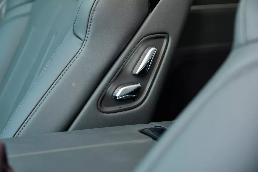 Bên hông ghế phụ phía trước có nút bấm chỉnh tiến/lùi điện, giúp người ngồi sau chủ động sắp xếp không gian cần thiết.